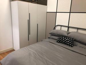 um quarto com uma cama e armários brancos em Bella Maison @ Sunway Velocity 中文房东 em Kuala Lumpur