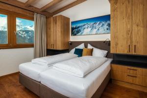A bed or beds in a room at Serfaus Alpensuites