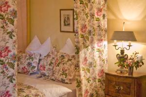 een slaapkamer met een bed met bloemgordijnen bij Schloss Amerang in Amerang