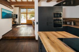 cocina con armarios negros y encimera de madera en Serfaus Alpensuites en Serfaus