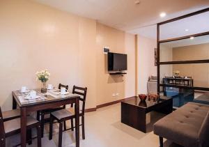 uma sala de jantar e sala de estar com uma mesa e um sofá em RedDoorz @ H.F. Golden Travellers Inn em Iloilo City