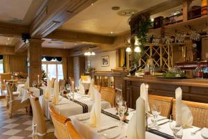 a restaurant with white tables and chairs and a bar at Landhaus Grum in Hattingen