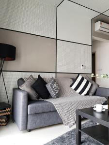 uma sala de estar com um sofá com almofadas em Bella Maison @ Sunway Velocity 中文房东 em Kuala Lumpur