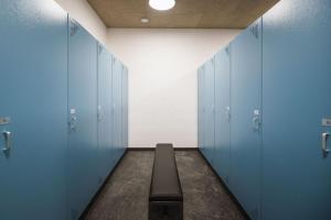 a hallway with blue lockers with a bench in it at AhriaNova in Sand in Taufers
