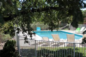 - une piscine avec 4 chaises longues à côté dans l'établissement Mas De Baumes, à Ferrières-les-Verreries