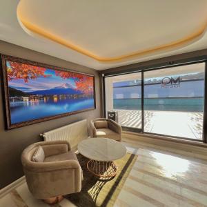 MQ Hotel Suites في Arnavutköy: غرفة معيشة مع تلفزيون وطاولة وكراسي