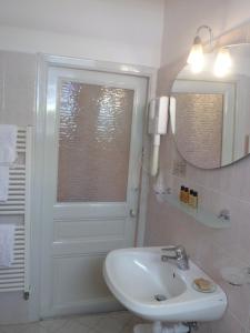 a bathroom with a sink, mirror and bathtub at Hotel Liberty in Sanremo