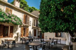grupa stołów i krzeseł przed budynkiem w obiekcie Hotel Torre San Juan w mieście San Juan de Alicante