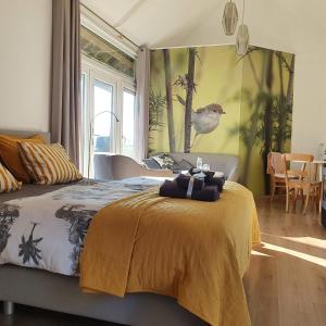 a bedroom with a bed with a yellow blanket on it at Hofstede 's Gravenhoek in Wissenkerke