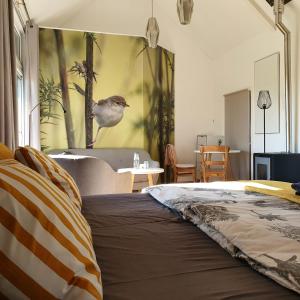 a bedroom with a bed with a bird on the wall at Hofstede 's Gravenhoek in Wissenkerke