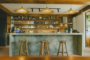 uma cozinha com um bar com dois bancos em The Wooden Gate em Xuân Sơn
