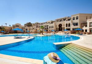 a person sitting in a chair in front of a swimming pool at Azzurra Sahl Hasheesh in Hurghada