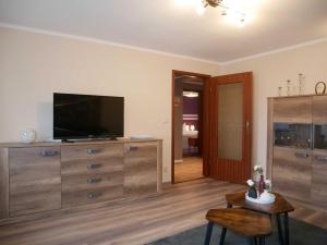 a living room with a flat screen tv on a dresser at Ferienwohnung Mecklenburgische Seenplatte in Schwichtenberg