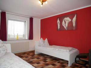 a bedroom with red walls and a bed and a window at Ferienwohnung Mecklenburgische Seenplatte in Schwichtenberg