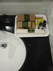 a bathroom sink with a tray of sponges on it at Hotel Emerald Regency in Putuppalli