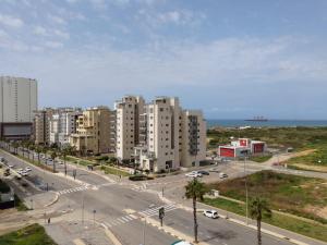 a city with tall buildings and a street with cars at SEA& SUN in H̱adera