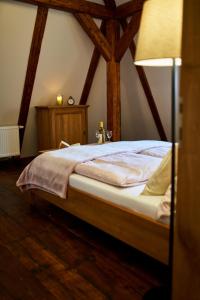 ein Schlafzimmer mit einem Bett in einem Zimmer mit Holzdecken in der Unterkunft Baroque chaplain house Kaplanka 1796 A. D. - historical luxury apts in Bohemian Paradise in Železný Brod