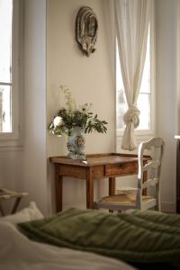 una habitación con una mesa y un jarrón de flores en Maison d'artistes - Pavillon Southway en Marsella