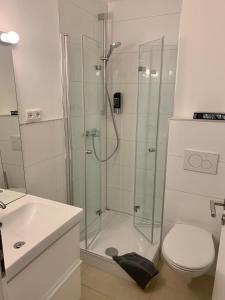 a bathroom with a shower and a toilet and a sink at Hotel Prinz Carl in Neckarsulm