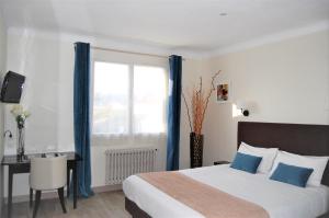 een slaapkamer met een bed, een bureau en een raam bij Hotel Le Goeland in Barbâtre