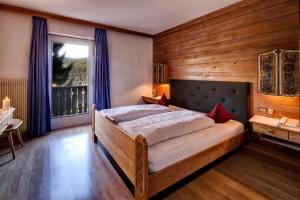 a bedroom with a bed in a room with a window at Solaia Hotel & Guesthouse in Castelrotto