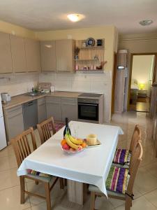 - une cuisine avec une table et un bol de fruits dans l'établissement Apartment "Onkel", à Šibenik