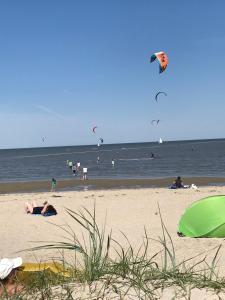 a group of people on the beach flying kites at Ferienwohnungen Koch OG adult only in Wangerland
