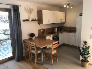 a kitchen with a wooden table and chairs and a table at Fewo Glücksfall in Berchtesgaden