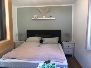 1 dormitorio con 1 cama con 2 mesitas de noche y 2 mesas en Fewo Glücksfall, en Berchtesgaden