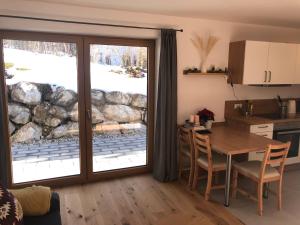 cocina con mesa y puerta corredera de cristal en Fewo Glücksfall, en Berchtesgaden