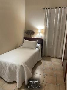 - une chambre avec un lit et du carrelage dans l'établissement Casa rural Les Sorts, à Rosell