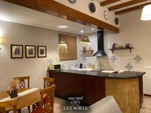 a kitchen with a counter and a table and a counter top at Casa rural Les Sorts in Rosell