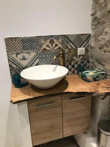 a bathroom with a white bowl sink on a counter at Petite Maison pleine nature in La Bastide-Pradines
