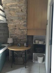 a small kitchen with a table and a stone wall at Petite Maison pleine nature in La Bastide-Pradines