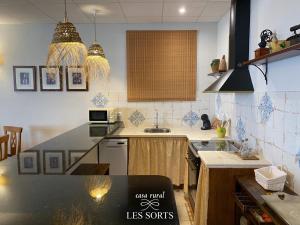 - une cuisine avec un comptoir noir dans une pièce dans l'établissement Casa rural Les Sorts, à Rosell