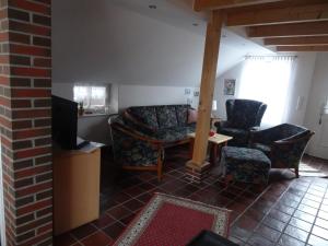 ein Wohnzimmer mit einem Sofa und 2 Stühlen in der Unterkunft Ferienhaus 257 R in Eckwarden in Eckwarden