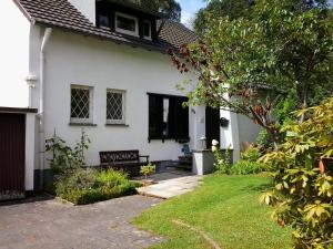 a white house with a bench in the yard at Villa Donar in Cologne