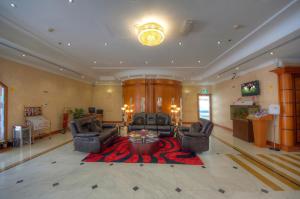 sala de estar amplia con 2 sillas y mesa en La Villa Najd Hotel Apartments, en Dubái