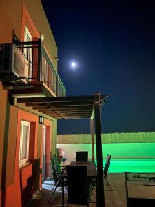 een patio met een tafel en stoelen op een huis bij VILLA MARIE Agradable y tranquila MAISON con piscina in Corralejo