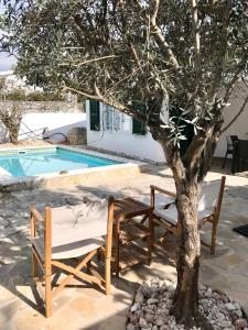 a table and chairs next to a tree next to a pool at Chalet La Rosa in Cala Blanca
