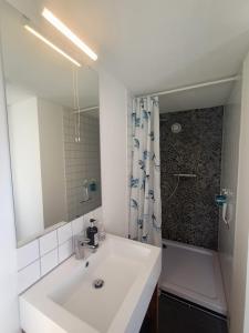 a white bathroom with a sink and a shower at Ausblick Maisenbach, Talstraße in Bad Liebenzell