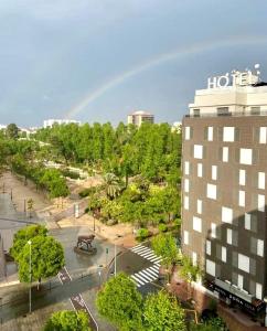 um arco-íris no céu sobre um parque com um edifício em Doña Lola em Castellón de la Plana