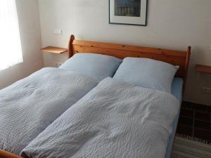1 Schlafzimmer mit 2 Betten und weißer Bettwäsche in der Unterkunft Ferienhaus 257 R in Eckwarden in Eckwarden