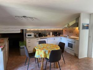 a kitchen with a table and chairs and a kitchen with a table and a kitchen at Geräumiges Domizil mit Bergblick in Oberwössen