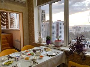 een tafel met borden in een kamer met een raam bij Sunrise Apartments in Doesjanbe