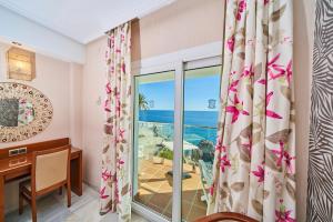 a room with a desk and a window with a view of the ocean at Hotel Balcón de Europa in Nerja