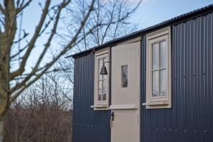 um edifício azul e branco com janelas em The Hut em Ashbourne