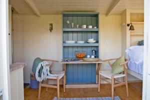 een kamer met een tafel en stoelen en een bed bij The Hut in Ashbourne