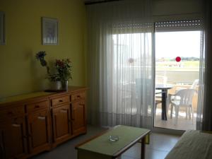 d'un salon avec une table et une porte coulissante en verre. dans l'établissement APCOSTAS Ses Illes, à Blanes