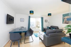 a living room with a couch and a table at ALTIDO Bright 3-bed flat overlooking The Clyde in Glasgow
